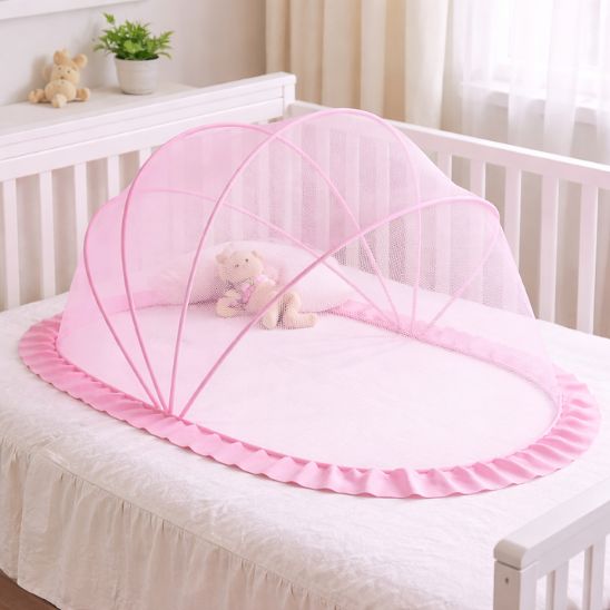 Moustiquaire lit bebe rose sur lit à barreaux avec jouets