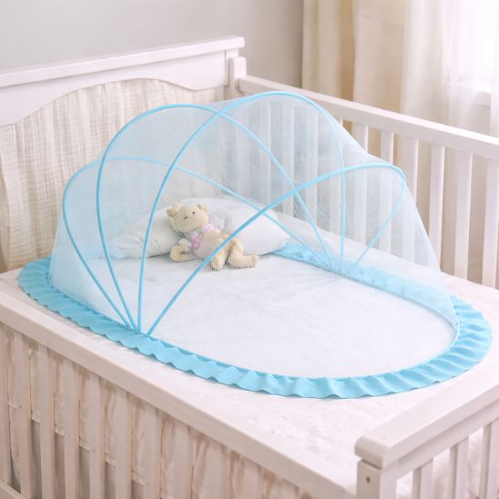 Moustiquaire lit bebe bleu sur lit à barreaux avec jouets