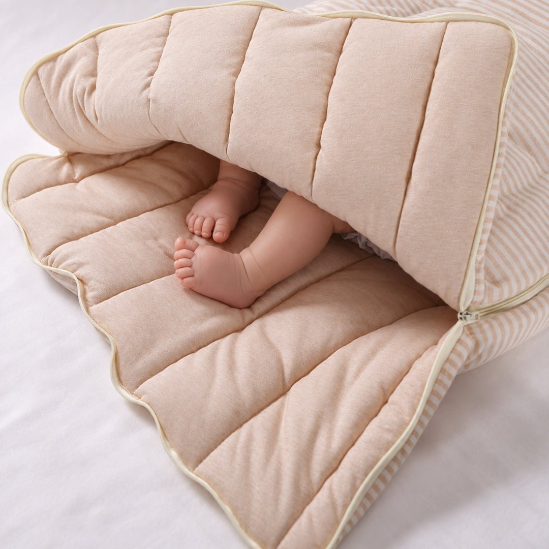 Petits pieds de bébé dans l'intérieur matelassé du nid d'ange
