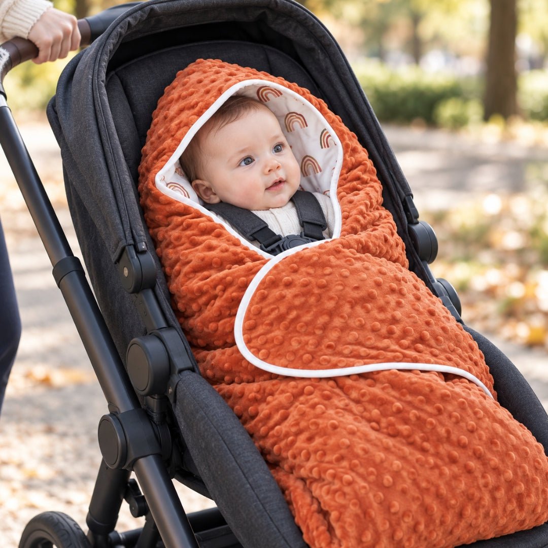 Bébé au chaud dans le nid d'ange minky terracotta, en balade en poussette