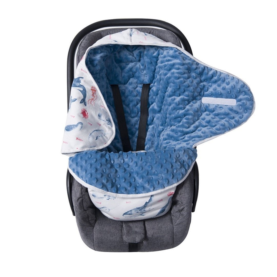Nid d'ange minky bleu Monde Marin ouvert dans un cosy, harnais passé