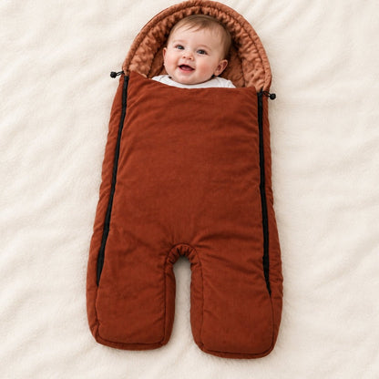 Bébé souriant dans un nid d'ange poussette caramel