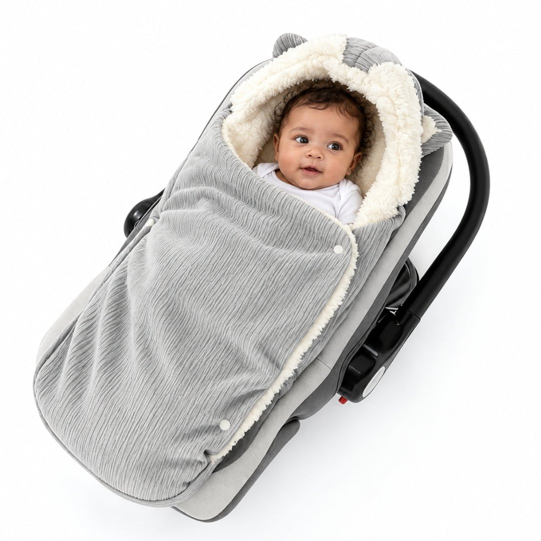 Bébé dans le nid d'ange siège auto gris