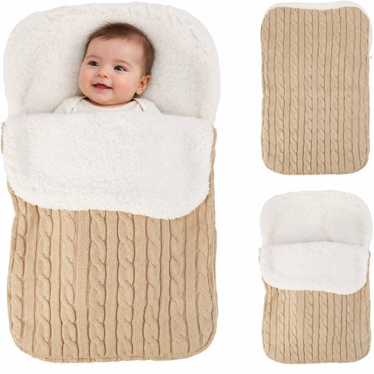 Bébé souriant dans son nid d'ange tricot torsadé