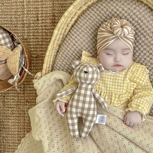 Ourson en peluche à carreaux utilisé comme décoration de chambre bébé