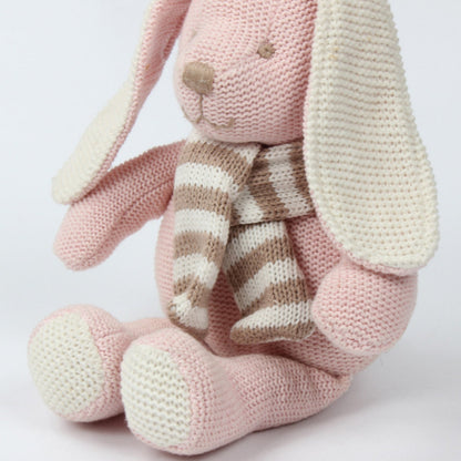 Gros plan sur l'écharpe rayée et les pattes en tricot de la peluche lapin