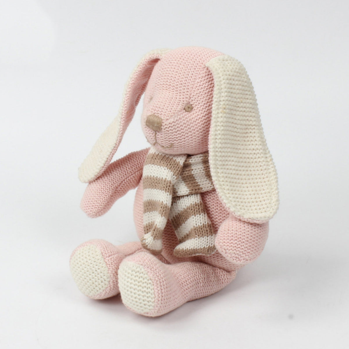 Peluche au tricot lapin rose vue de profil, longues oreilles crème