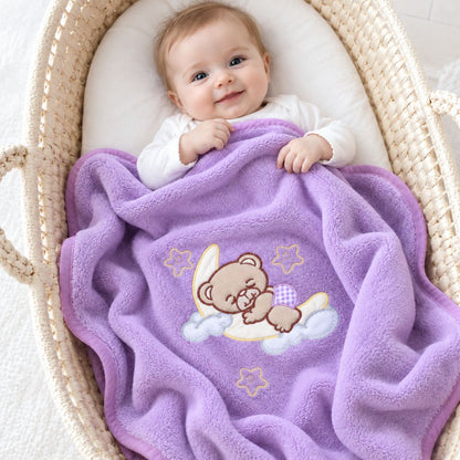 Bébé souriant dans un couffin sous la petite couverture bébé violette