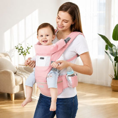 Porte bébé rose avec siège de hanche et porte-biberon – bébé souriant porté face au monde, décor intérieur clair