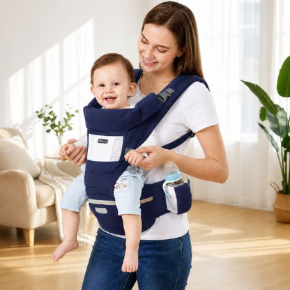 Porte bébé bleu marine avec siège de hanche et porte-biberon – bébé souriant porté face au monde, intérieur lumineux