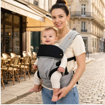 Porte bébé ergonomique coton gris – maman et bébé souriant dans une rue parisienne, terrasse café en arrière-plan