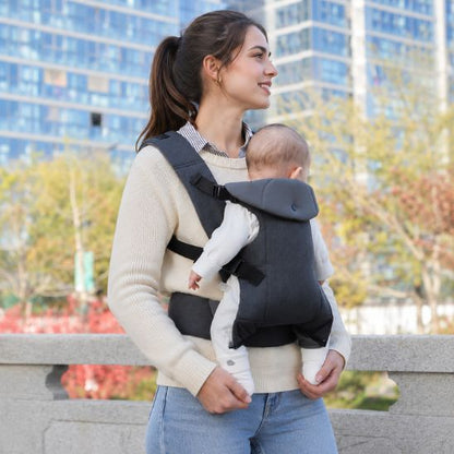 Porte bébé physiologique gris – maman en promenade en ville, bébé porté face au parent, décor urbain