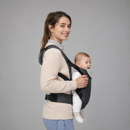 Porte bébé physiologique gris – maman souriante de profil, bébé porté face au monde, fond neutre