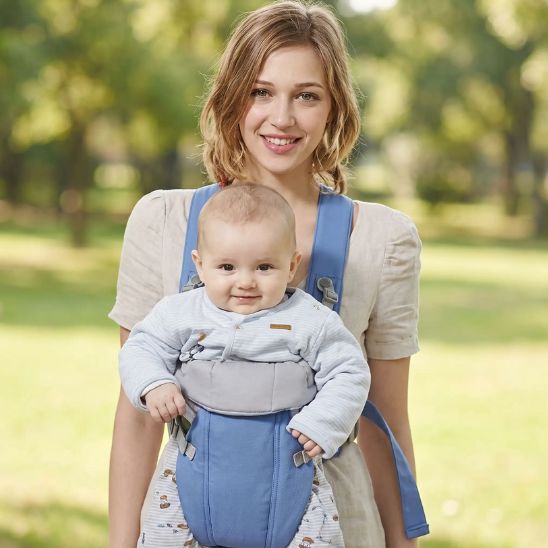 Porte bébé physiologique bleu ciel – maman en balade en ville, bébé porté face au parent, décor urbain