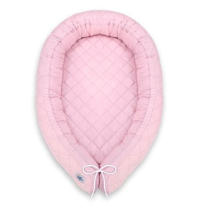 Réducteur de lit bébé rose, vue de dessus, forme ovale matelassée