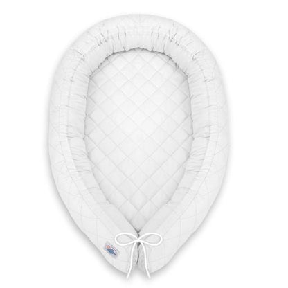 Réducteur de lit bébé blanc vu de dessus sur fond blanc