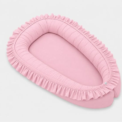Réducteur de lit bébé à volants rose, vue de côté
