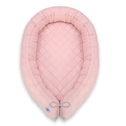Réducteur de lit bébé rose avec cordon gris, vu de dessus sur fond blanc