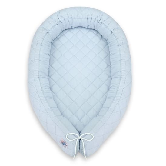 Réducteur de lit bébé bleu ciel vu de dessus sur fond blanc