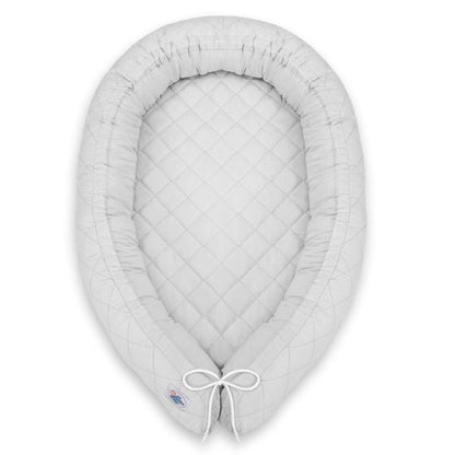 Réducteur de lit bébé gris vu de dessus sur fond blanc