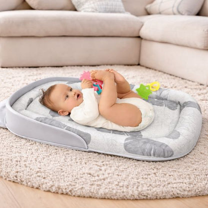Bébé qui joue avec jouets colorés posé sur réducteur de lit bébé pliable Tropical comme matelas de sol salon