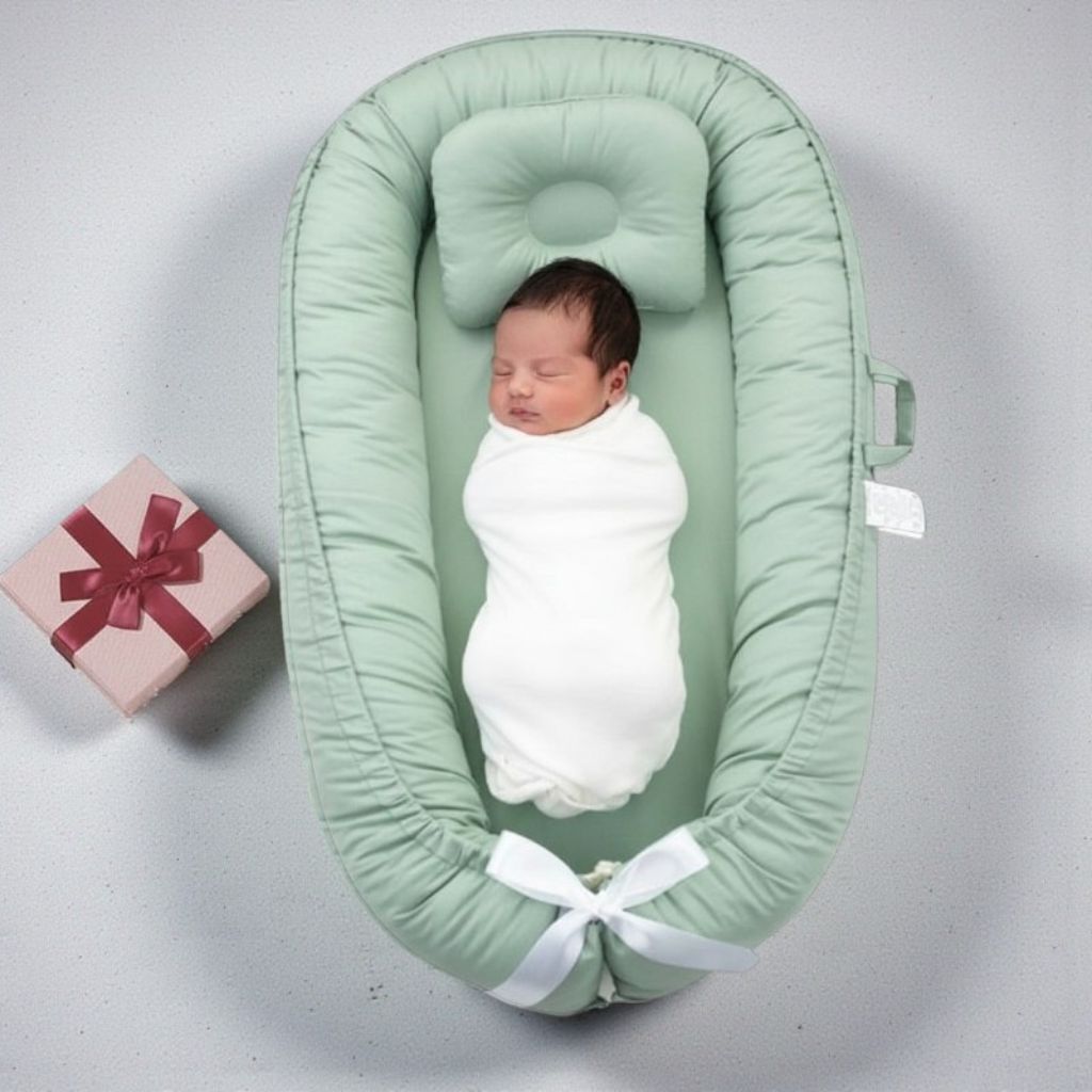 Réducteur de lit bébé vert pastel léger et transportable