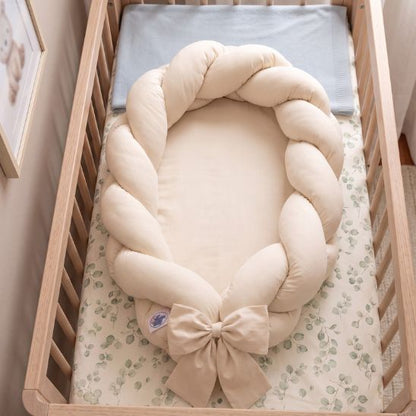 Réducteur de lit tressé beige sur drap motif eucalyptus, lit à barreaux