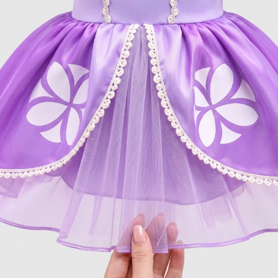 Détail de la jupe mauve en tulle et des motifs floraux de la robe bébé