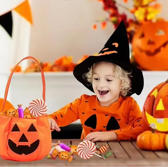 Sac Halloween enfant citrouille rempli de bonbons sur table avec décoration d’Halloween – Spot Bébé