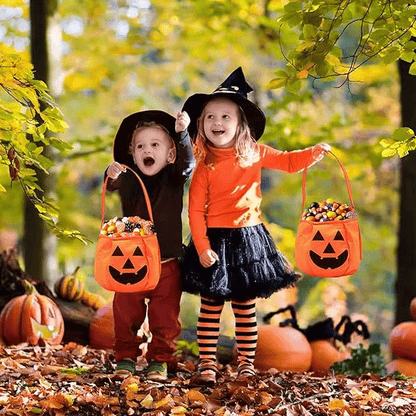 Deux enfants en costume portant un sac Halloween citrouille rempli de friandises – Spot Bébé