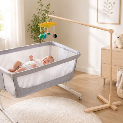 Bébé allongé dans son berceau sous le support mobile bébé