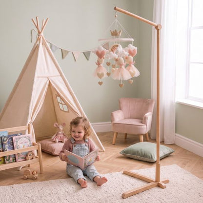 Enfant jouant près du support mobile bébé et d'un tipi