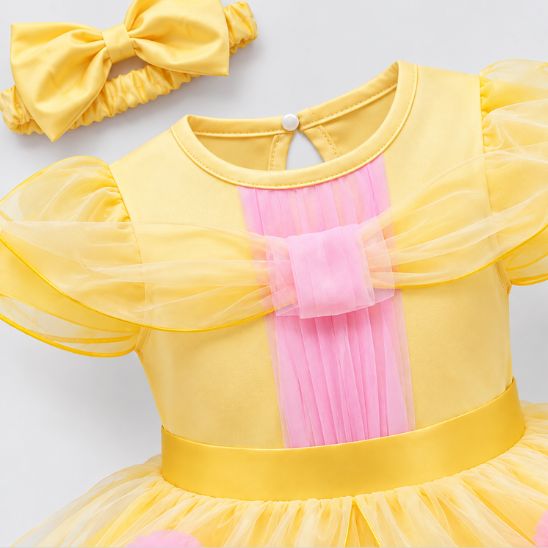 Détail du corsage jaune et rose et des manches légères de la robe bébé