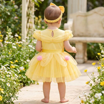 Robe de fête bébé jaune vue de dos dans un jardin fleuri