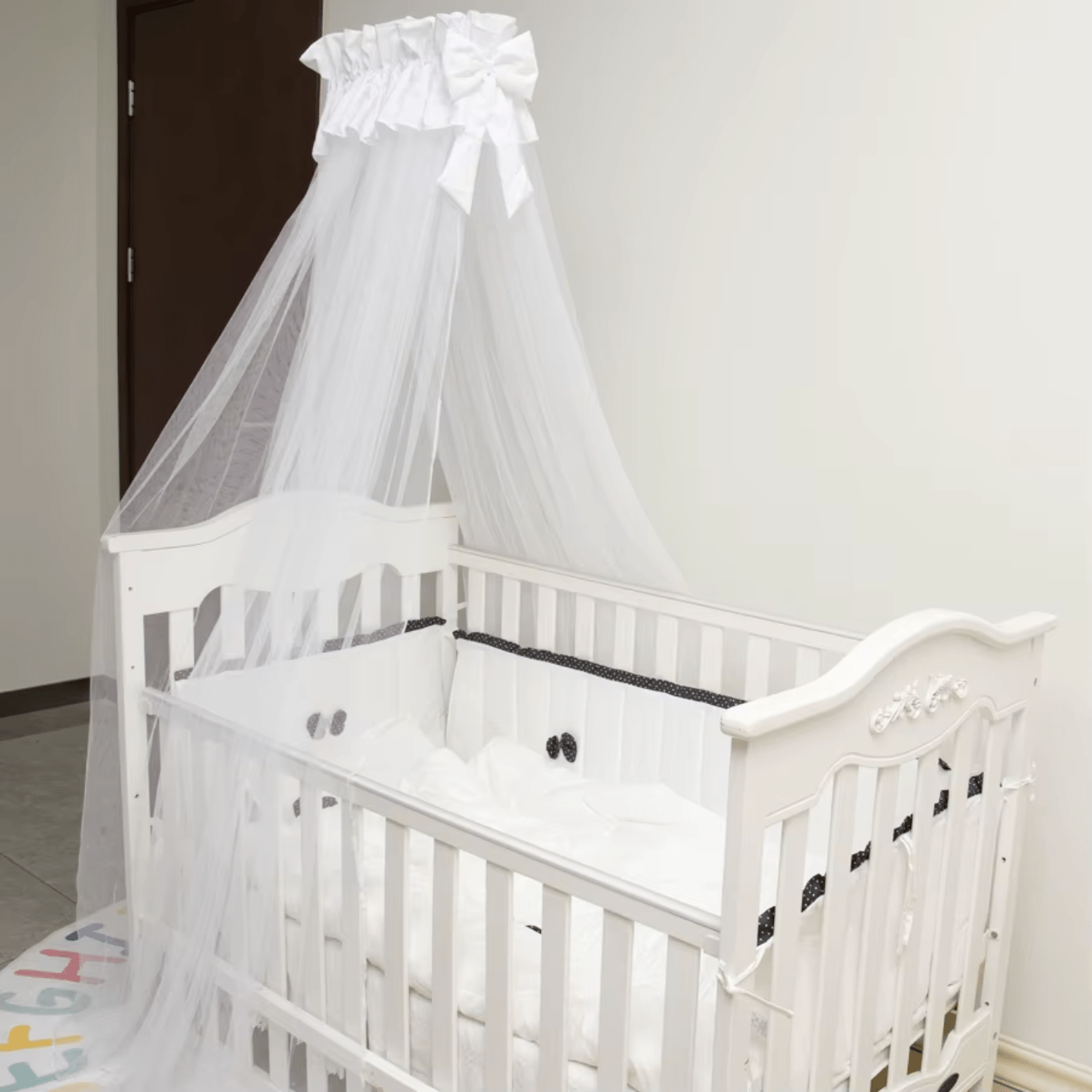 Décoration de chambre bébé avec tour de lit blanc élégant et moustiquaire fine.