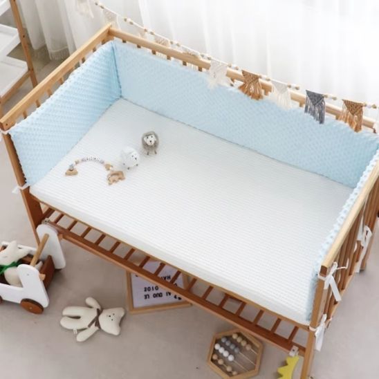 tour de lit bébé doux cocon installé dans une chambre bébé chaleureuse