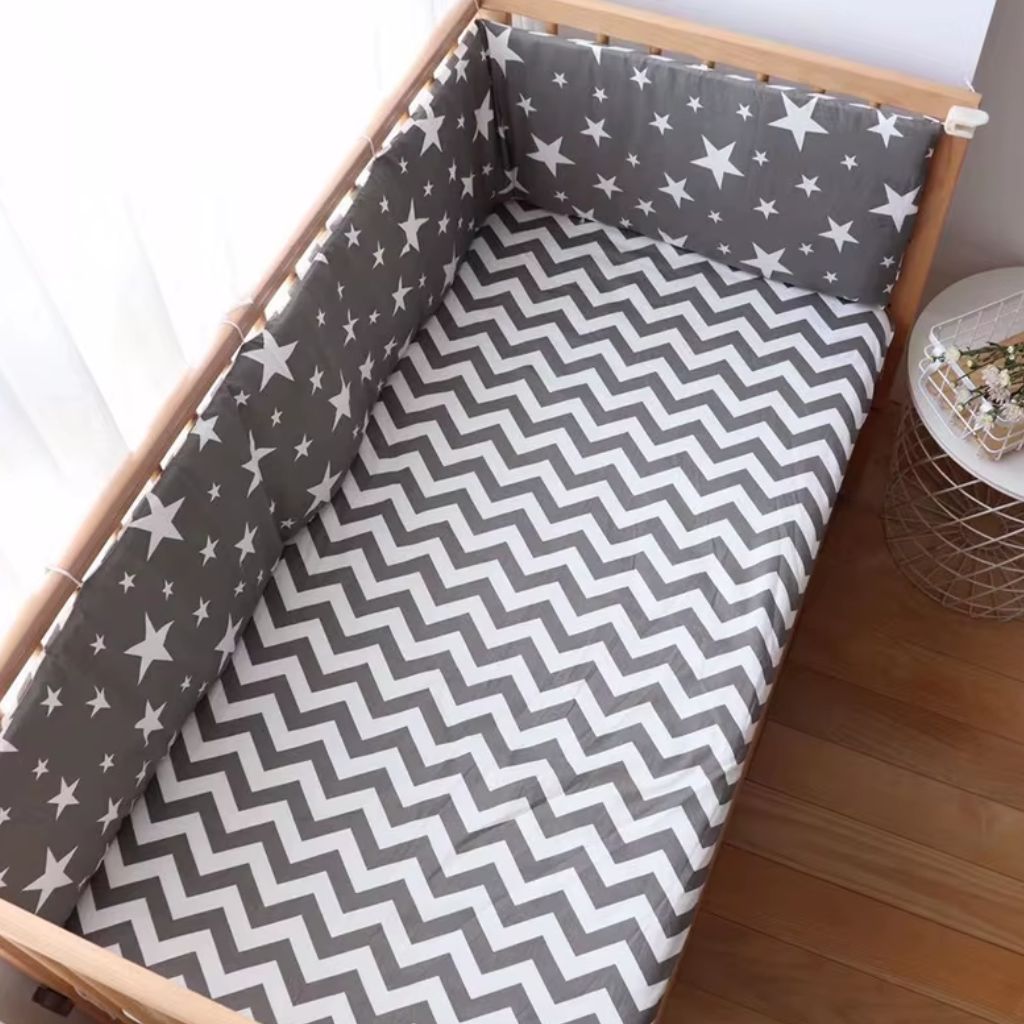 Tour de lit bébé garçon avec drap housse dans un lit bébé en bois naturel