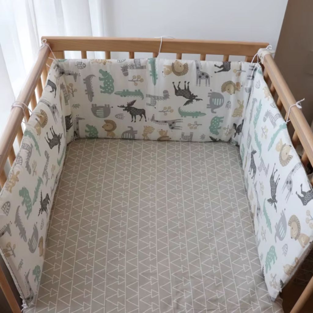 Tour de lit bébé garçon avec drap housse installé dans un lit bébé
