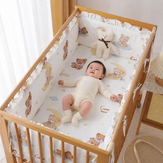 Tour de lit bébé ourson bébé allongé souriant dans berceau bois naturel