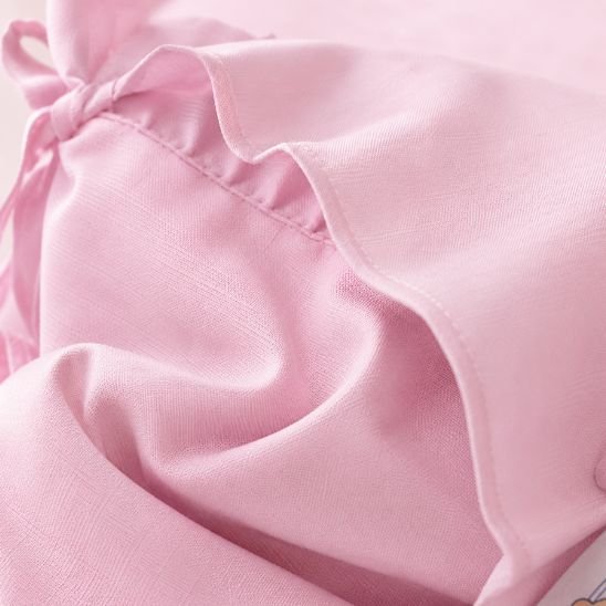 Détail du tissu et du volant du tour de lit bébé rose