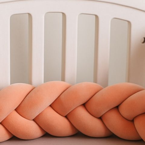 Tresse de lit rose saumon alliant confort et sécurité pour bébé


