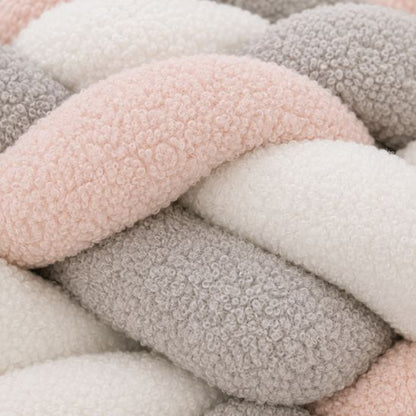 Tresse de lit bébé multicolore, gros plan sur la texture bouclette rose, grise et blanche