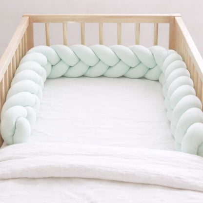 Tresse de lit bébé tressée vert d'eau installée en forme U dans berceau bébé