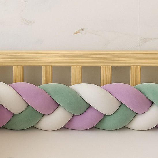 Tresse de lit bébé vert sauge, lila et blanc utilisée comme barrière de protection