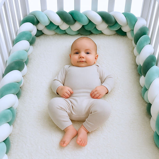 Bébé apaisé dans son lit protégé par une tresse de lit vert sauge