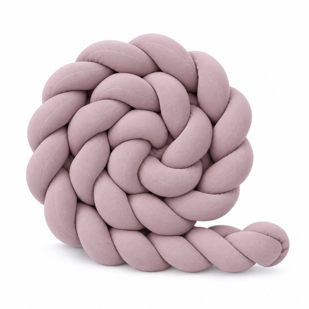 Tresse de lit enfant unie vieux rose enroulée sur fond blanc