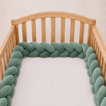 Tresse de lit vert de gris installée le long d'un lit à barreaux