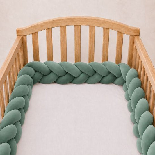 Tresse de lit vert de gris installée le long d'un lit à barreaux