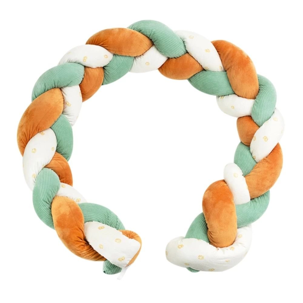 Tresse de lit bébé 3 brins vert sauge et camel installée dans un espace de jeu avec bébé.