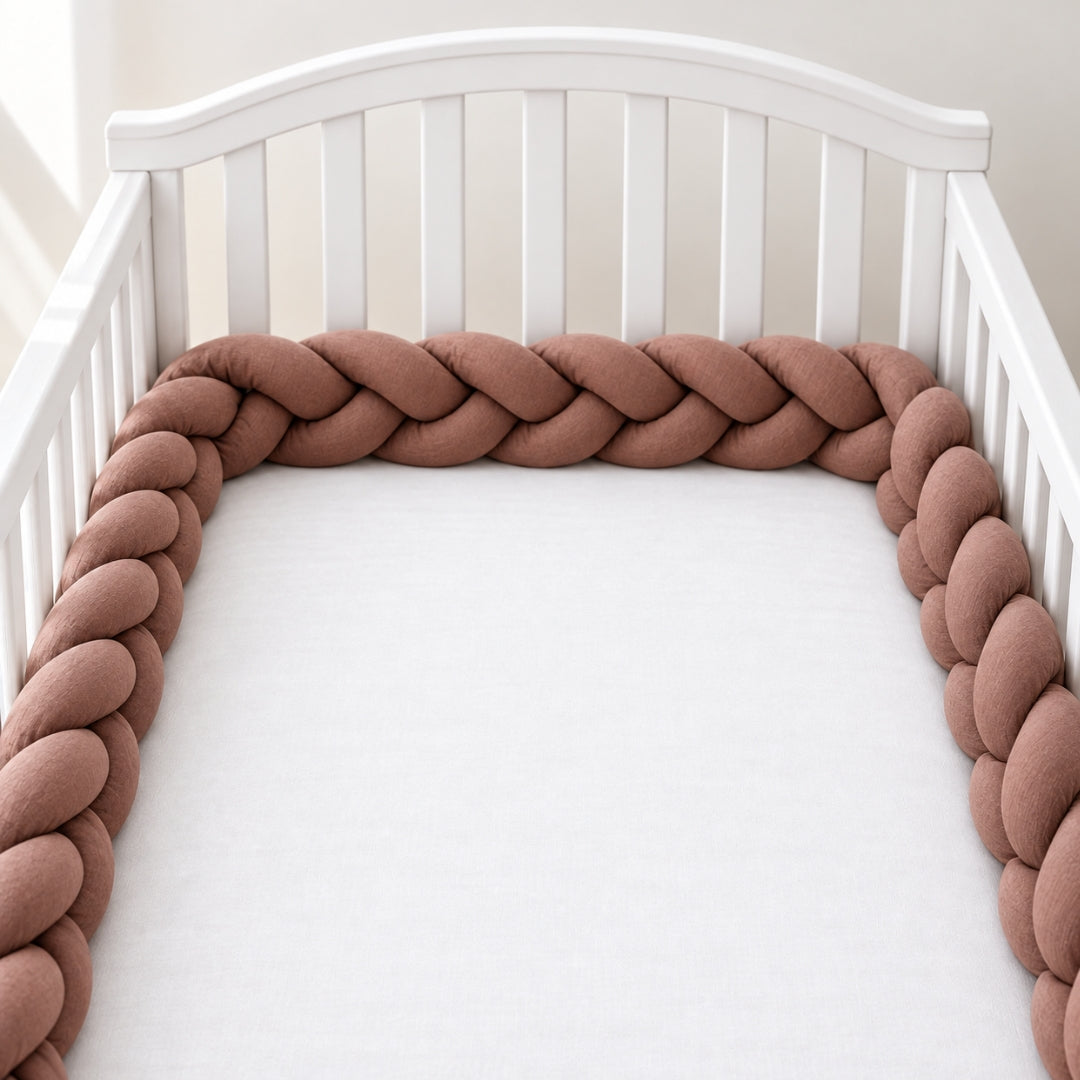 Tresse tour de lit bébé Jardin unie chocolat dans un lit blanc